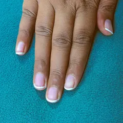 A clean and simple French manicure on short, natural nails. The thin white line at the tip gives a fresh and polished look that's perfect for everyday wear.