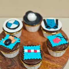 The full set of six custom cupcakes, combining themes of swimming and motorcycling. It's a unique and personal way to celebrate a relationship.