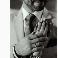A close-up, black and white shot of the couple's hands, now adorned with engagement rings. This photo is a simple, powerful symbol of their commitment.