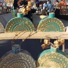 My half-moon shaped vases on display at The Lil Flea market. The intricate lace texture and beautiful turquoise glaze make them a customer favorite.