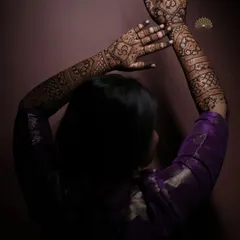 An artistic shot of a client showcasing her full-arm engagement mehndi, with the dark stain beautifully captured.