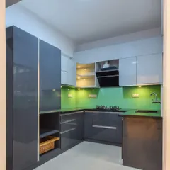 This view shows the tall unit and open shelving in the kitchen, providing a mix of concealed and easy-access storage. The under-cabinet lighting ensures the workspace is always well-lit.