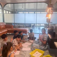 The children are gathered on the floor with worksheets after our roller coaster story. They are applying the coding logic they just learned to a fun, hands-on activity.