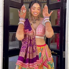 A happy bride showing off her Mehndi look. The intricate braid with the heavy accessory at the back is the star of her hairstyle.
