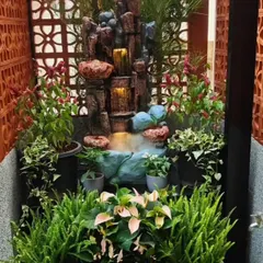 A compact, custom water feature designed for a small courtyard. The setup includes a small waterfall, integrated mist maker, and surrounding pockets for planting ferns and other moisture-loving plants.