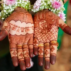 A close-up of a heartwarming baby shower mehendi. One hand features cute hanging baby clothes and toys, while the other announces "I'm Coming Soon."