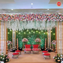 This Vidhi Mandap is a sanctuary where tradition meets artistry. We combined a lush green wall with cascading white florals and rich red seating to create a sacred space that feels both grand and intimate.