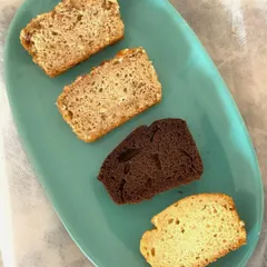 A tasting platter of four different tea cake slices, showcasing the variety I offer. You can see the different textures and colours, from a dark chocolate loaf to a classic vanilla.