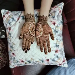 A lovely and balanced henna design on both hands, perfect for a wedding guest or festive occasion. The central floral mandala is a classic element.