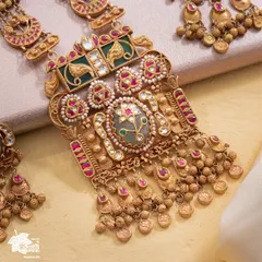 A detailed view of the Maharani Haar's central pendant. Here, you can see the masterful layering of gold, the precision of the gemstone setting, and the delicate pearl work that defines its royal character.