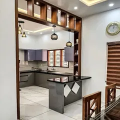 A beautiful example of a semi-open kitchen with a pass-through and breakfast bar. The wooden frame provides a visual connection to the dining area, making it easy to entertain guests while cooking.