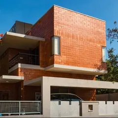 An alternate view of the Reshma Residence highlights its cubist architectural form. The interplay of projecting and recessed volumes creates visual interest and provides shaded balconies and carports, blending form with function.