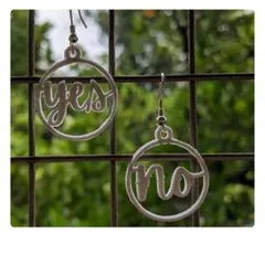 A pair of our "yes/no" earrings, 3D printed and hanging on display. This is a fun, quirky design that shows the playful side of what we can create at the lab.