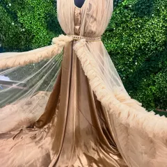 A detailed look at the flowing fabric of our beige ruffle gown. The combination of satin and tulle gives it a luxurious and ethereal feel.