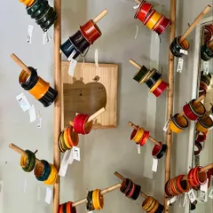 Our lightweight Channapatna bangles make a sweet wooden sound when worn. This display at our store showcases the variety of colors and designs available, each set a small piece of wearable art.