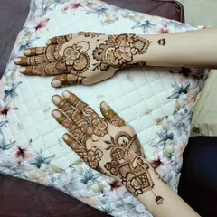 A lovely pair of hands with non-matching but complementary designs. One hand features a floral vine, while the other has a more structured, geometric pattern, showing how you can mix styles.