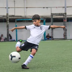A player practices his shooting form, capturing the moment of impact and follow-through required for a powerful and accurate strike on goal.
