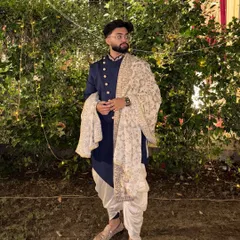 A client looking sharp in our navy blue Indo-Western set with a printed dushala. This is a great rental option for a sangeet or reception, offering a modern yet traditional vibe.