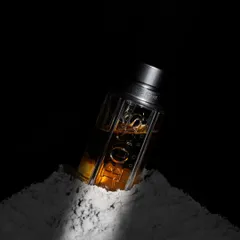 Here, I experimented with textures and dramatic lighting to create a moody and artistic product visual. The perfume bottle is partially set in fine white powder, with a single, sharp light source creating deep shadows and highlighting the liquid's amber color. This is a great example of conceptual product photography.