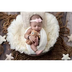 A wider angle of this serene sleeping pose shows more of the cozy setup. The soft fur, woven basket, and star decorations create a dreamy, celestial feel for this baby girl's portrait.