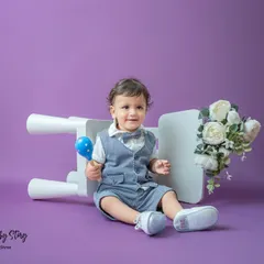 A dapper little gentleman! This toddler portrait uses a solid lavender background to make his smart vest and bow tie pop. The simple props add a touch of playfulness.