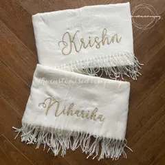 Wrap yourselves in warmth with these elegant personalized shawls. Made from soft fabric with delicate tassels, each is embroidered with a name in a beautiful script, perfect for a coordinated couple's gift.