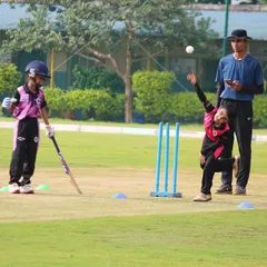A young bowler from our U-10 program learning the basics of a run-up and delivery under the watchful eye of an umpire.
