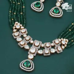 A vision in green, this necklace is where modern grace meets timeless grandeur. Uncut polki diamonds are set against a cascade of deep green emerald beads, centered with magnificent emeralds. This is a statement of sophisticated luxury.