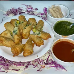 Crispy cheese corn rolls served with green chutney and sweet tamarind sauce, a perfect bite-sized appetizer.