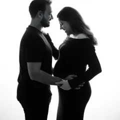 A simple silhouette in black and white can tell the most powerful story. This image captures the shared joy and anticipation between two people about to become parents.