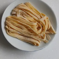 Strands of handmade tagliatelle. There is no comparison to the texture and flavor of pasta made fresh with your own hands.