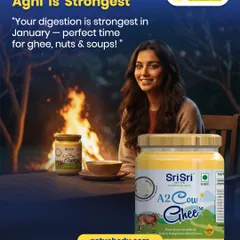 Did you know your 'Agni' or digestion is strongest in January? This image, featuring a woman by a fire, explains why it's the perfect time to enjoy nourishing foods like A2 Cow Ghee from Sri Sri Tattva.