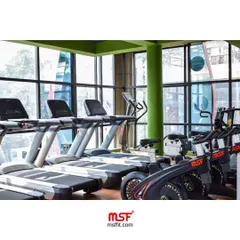 A row of our commercial treadmills and spin bikes, ready for members at a modern fitness center.