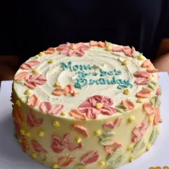 A beautiful custom cake for a mom's 90th birthday. We worked with the family to create this special design with soft, impressionistic buttercream flowers, making it a memorable part of their celebration.