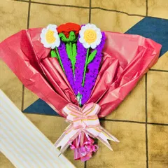A cheerful bouquet featuring crochet daisies and lavender, wrapped in bright pink paper. This arrangement is perfect for birthdays or just to brighten someone's day.