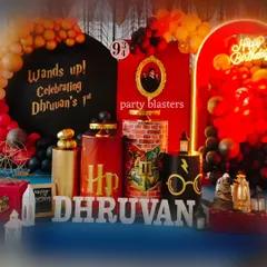 Wands up for a magical Harry Potter first birthday. This detailed setup features iconic elements like the Platform 9 3/4 sign, a Sorting Hat, themed pedestals, and a custom "Wands up!" backdrop, all in the classic Gryffindor colors.