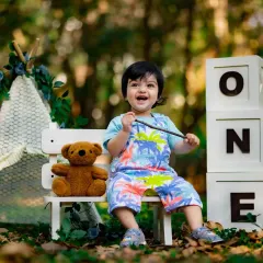 A big, happy smile from this little boy during his outdoor first birthday session. The park setting is perfect for energetic toddlers.