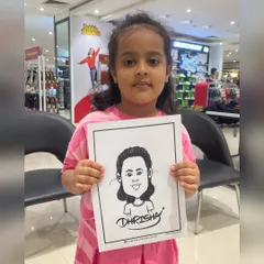 A little girl proudly holding up her caricature at a mall event. We love drawing for children and capturing their unique personalities.