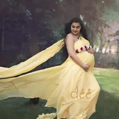 A gentle and serene maternity photo with our yellow trail gown. The soft fabric flows beautifully, adding a touch of elegance to this outdoor shot.