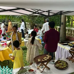 A wider view of the kids' party brunch. You can see guests of all ages enjoying the food in a relaxed, beautiful garden setting. I create an atmosphere, not just a menu.