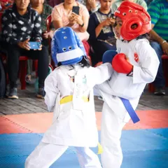 An action shot from a Kumite match, showing a student executing a controlled kick. These events teach valuable lessons in timing, strategy, and respect for one's opponent.