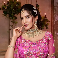 For a modern reception or sangeet, a statement Kundan jewellery set can be absolutely perfect. This gorgeous piece with intricate pearl work beautifully complements the bride's vibrant pink lehenga, creating a look that is both elegant and glamorous.
