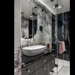 This luxurious bathroom makes me so happy. We used a dynamic lavender spider marble and a black marquina marble, pairing them with matte black hardware and crystal knobs for a truly glamorous feel.