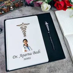 A thoughtful gift for a doctor. This set includes a personalized A5 diary featuring their photo, name, and a caduceus symbol, plus a matching themed pen.