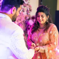 The bride places the ring on the groom's finger, a moment of mutual commitment and love, captured in a candid style.
