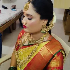 Our happy client Usha, ready for her big day. She is wearing a complete antique-finish bridal set, including a choker, long necklace, jhumkas, and a traditional maang tikka that beautifully frames her face.