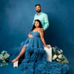 Create a beautiful memory with your partner. This flowing blue tulle gown with a ruffled train offers a romantic and ethereal look, perfect for capturing the connection and joy of your pregnancy journey together.