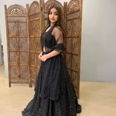 A beautiful black lehenga with delicate sequin work. The sheer dupatta adds a touch of elegance to this modern, pre-loved party outfit.