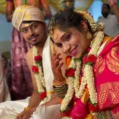 This happy couple shot showcases the complete Muhurtham look. Her makeup is bright and traditional, complementing the groom's attire and the vibrant colors of the ceremony.