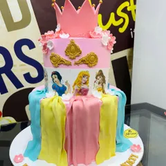 A cake fit for royalty, this 4kg Disney Princess design features edible images of Snow White, Aurora, and Belle. The tiers are decorated with fondant drapery in their signature colors and topped with a pink crown.